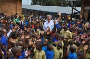 Fly and Help und Reiner Meutsch zwischen den lächelnden Kindern